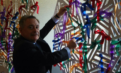 Minister Brendan Howlin ties a green ribbon on the World Conference tree to signal Ireland’s commitment to Disaster Risk Reduction 