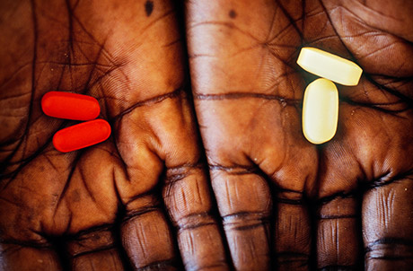 A pair of hands holding a pill in each. Photo: Panos.